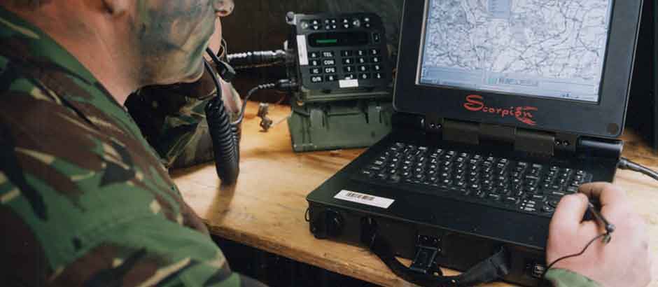 A soldier uses a tactical computing system while on the radio