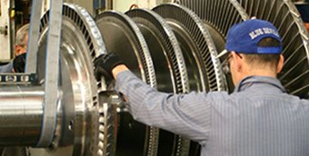 A worker examines a steam turbine