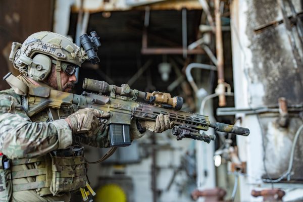 A soldier points a rifle with MRDCS