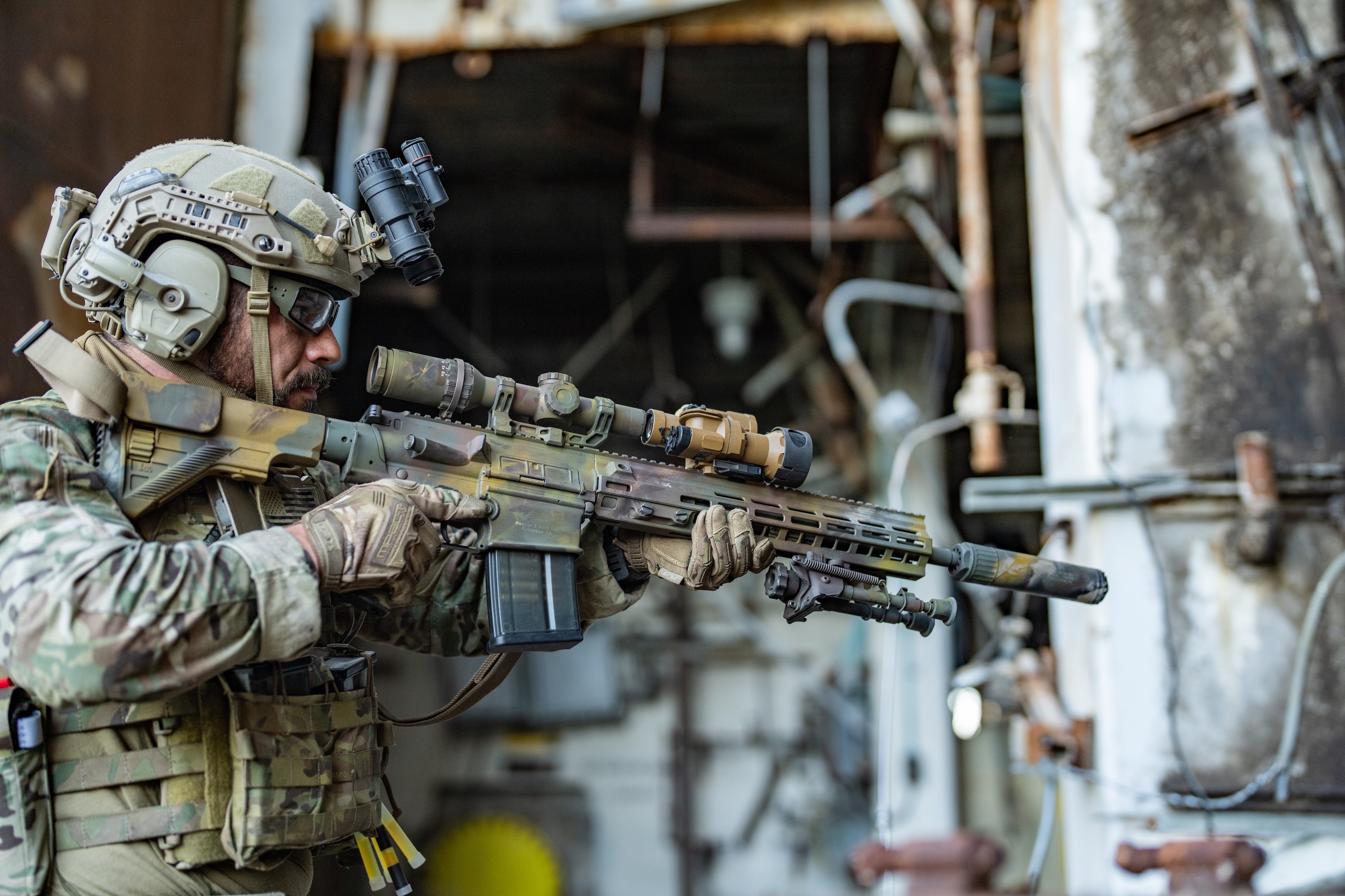 A soldier points a rifle with MRDCS