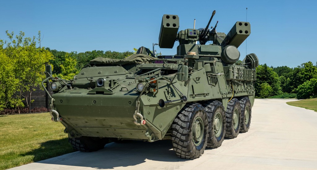 Eight-wheeled armored air defense vehicle equipped with missile launchers and a cannon on a paved roadway.